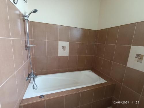 a bath tub in a tiled bathroom at MF Holiday Bungalow in Bandarawela