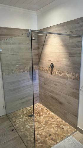 a shower with a glass door in a bathroom at Plett57 - Self Catering - Room No1 in Plettenberg Bay