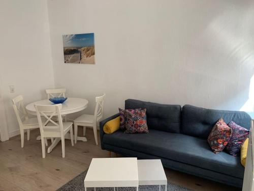 un salon avec un canapé bleu et une table dans l'établissement Gemütliche Altbauwohnung in Stuttgart Ostendplatz, à Stuttgart