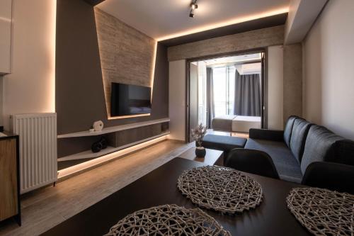 a living room with a couch and a tv at SKIA luxury living above the walls in Thessaloniki