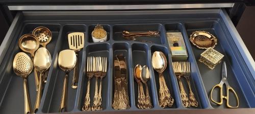 a tray filled with gold utensils and spoons at Spirit of Gozo unique penthouse in Xagħra