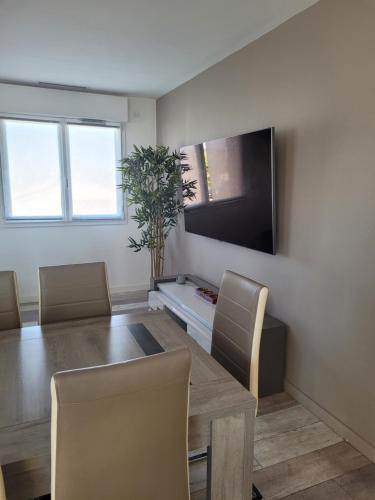 d'une salle à manger avec une table et une télévision à écran plat. dans l'établissement Charmante Maison GIBISA, au Muy