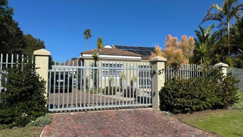a white gate in front of a house at Plett57 - Self Catering - Room No2 in Plettenberg Bay