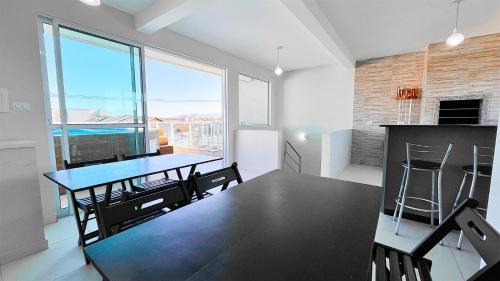 a kitchen and dining room with a table and chairs at Triplex com piscina e área gourmet in Guaratuba