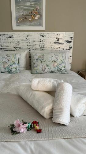 a bed with white blankets and pillows on it at Plett57 - Self Catering - Room No2 in Plettenberg Bay