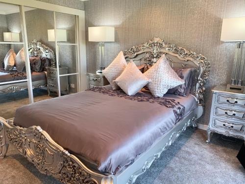 a bedroom with a large bed with a large mirror at Ayrs and Graces - Luxury Bed and Breakfast in Ayr