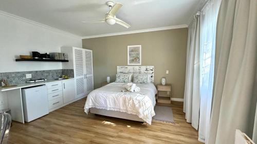 a bedroom with a bed and a desk in it at Plett57 - Self Catering - Room No2 in Plettenberg Bay