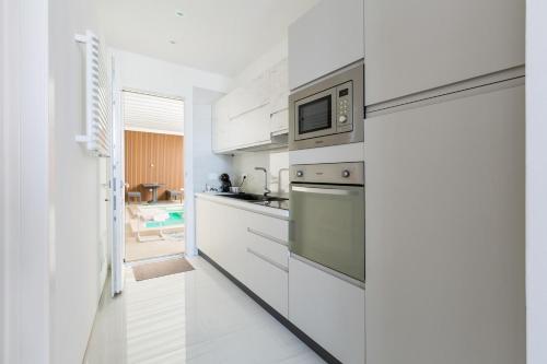a kitchen with white cabinets and a microwave at Pasitea Luxury Suite by BarbarHouse in Squinzano