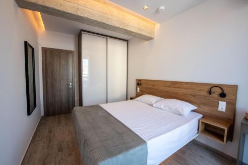 a bedroom with a large bed with a wooden headboard at SKIA luxury living above the walls in Thessaloniki