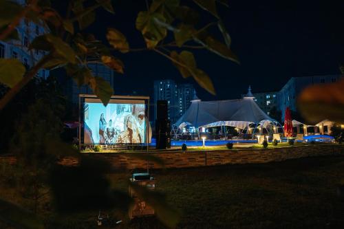 a stage with a large screen at night at Grand Fergana Hotel in Fergana