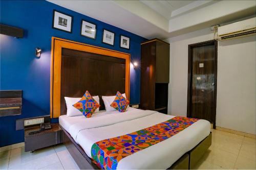 a bedroom with a large bed with a blue wall at Via Manas Residency in Mumbai