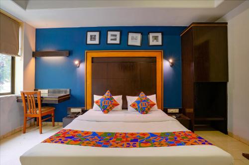 a bedroom with a large bed with a blue wall at Via Manas Residency in Mumbai