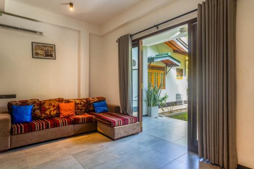 a living room with a couch and a sliding glass door at 18 Villa in Hikkaduwa