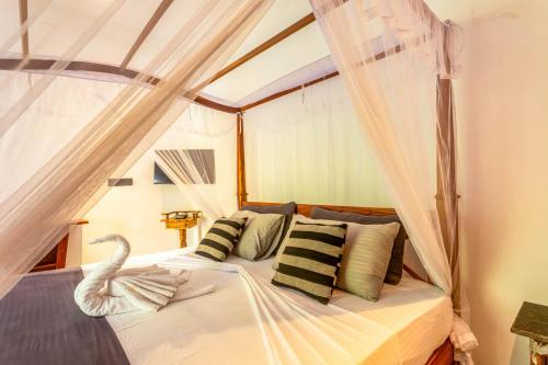 a bedroom with a bed with a swan on it at 18 Villa in Hikkaduwa