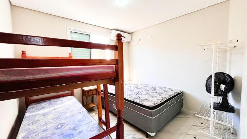 a small bedroom with a bunk bed and a bed at Triplex com piscina e área gourmet in Guaratuba