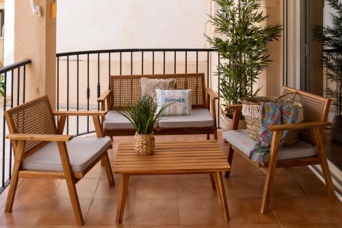 a patio with two chairs and a table and a bench at Villa Cruceiro in Los Belones