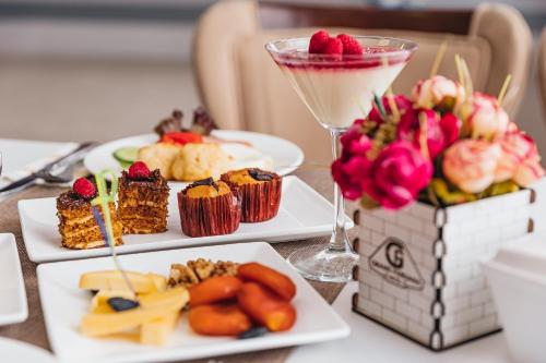a table with three plates of food and a drink at Grand Fergana Hotel in Fergana