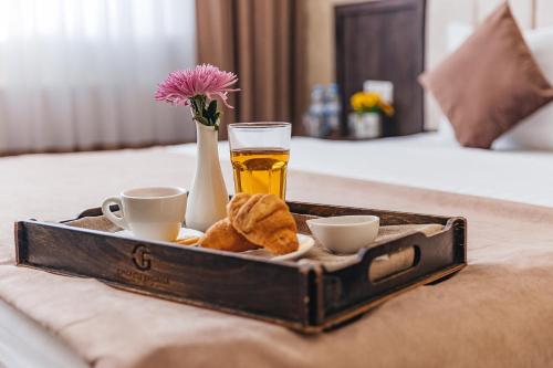 a tray with a glass of beer and two cups at Grand Fergana Hotel in Fergana