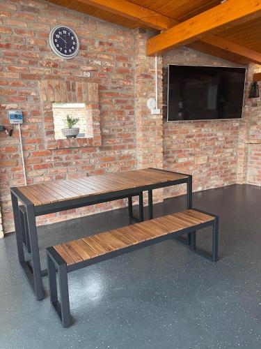 a table and bench in front of a brick wall at Ikervár-lak in Ikervár