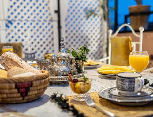 un tavolo con cibo e un bicchiere di succo d'arancia di Authentic house in the old Medina of Marrakech a Marrakech