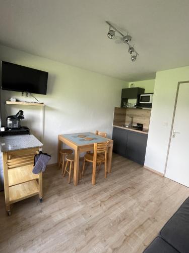 une petite pièce avec une table et une cuisine dans l'établissement Le repère du Nant- meublé classé 2 étoiles, à Morzine