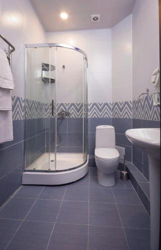 a bathroom with a shower and a toilet and a sink at Grand Fergana Hotel in Fergana