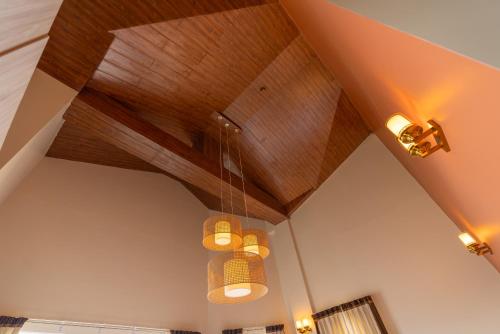 a ceiling with three chandeliers hanging from it at The Manor Luxury Apartments, Shimla in Mashobra