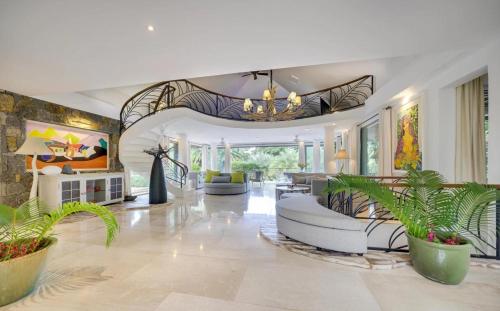 a living room filled with furniture and plants at La VILLA MAELA GOLF ANAHITA in Beau Champ