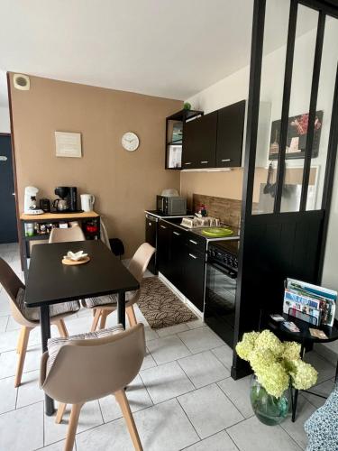 - une cuisine avec une table et des chaises noires dans la chambre dans l'établissement La Romance, à Fressenneville