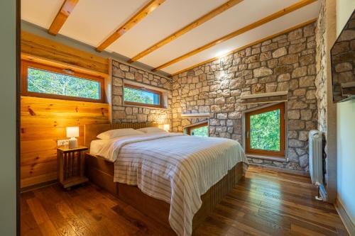 une chambre avec un lit et un mur en pierre dans l'établissement Vila Gospavino Guvno, à Žabljak