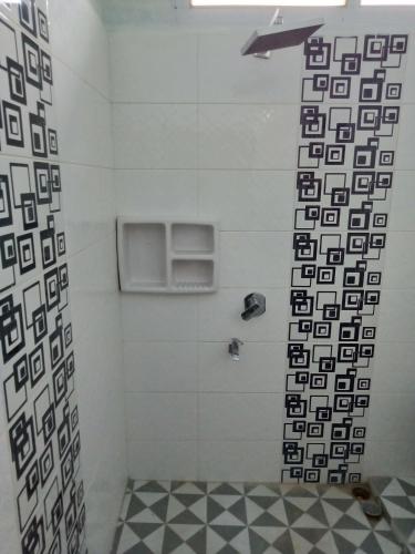 a bathroom with a shower with black and white tiles at Ratu Balqis Homestay in Banda Aceh