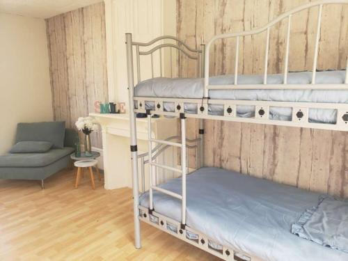 une chambre avec deux lits superposés et un canapé dans l'établissement Maison Familiale, à Pont-Rémy