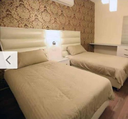 two beds in a hotel room with at Apartment in Amman