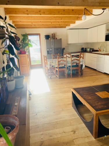 Il comprend une grande cuisine et une salle à manger avec une table. dans l'établissement Villa nichée dans un écrin de verdure, à La Valette-du-Var