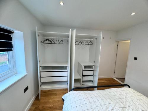 a white bedroom with a bed and a window at Wilmer House in Eastleigh
