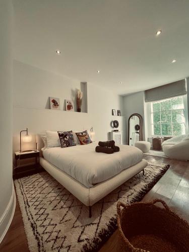 a bedroom with a large white bed with a rug at ROBERT HOUSE in London