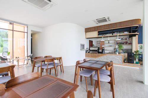 a room with tables and chairs and a kitchen at เดอะซีน คาบาน่า บีช รีสอร์ท ขนอม The Scene Cabana Beach Resort Khanom in Ban Plau