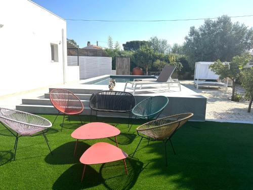 a group of chairs and a table on the grass at Elsa Holiday Home in Fontane Bianche