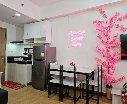 a kitchen with a table and a refrigerator at Lakwatsero Caviteño Suites in Trece Martires
