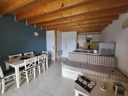 Cette chambre comprend un lit, une table et une cuisine. dans l'établissement Maison mer et piscine 3 nuits minimum, à Loc-Maria-Plouzané