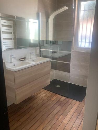 une salle de bain avec un lavabo blanc et une douche dans l'établissement La campagne proche de l Océan, à Saint-Gervais