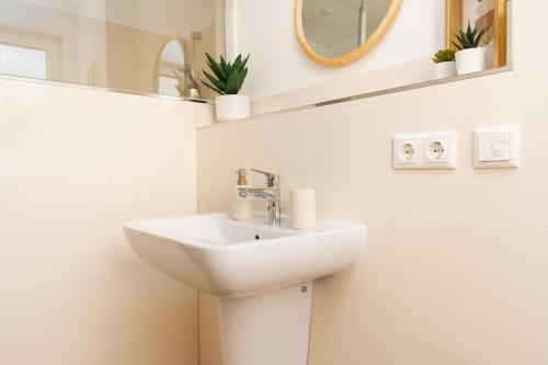 a white bathroom with a sink and a mirror at Idyllische Ferienwohnung am Schaalsee - Natur und Erholung pur in Zarrentin