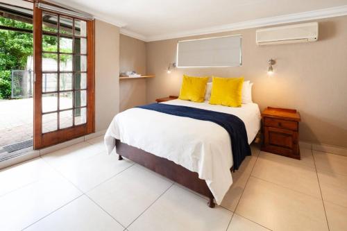 a bedroom with a large bed with yellow pillows at Farquhar Lodge in Ladysmith