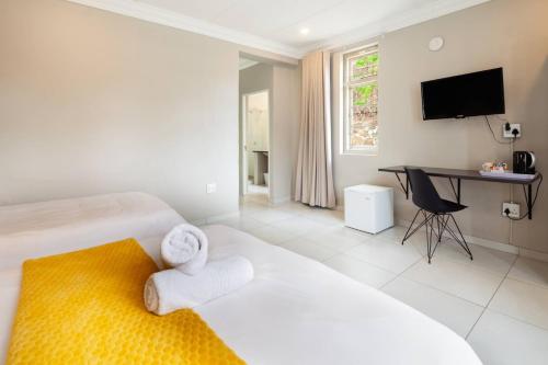 a hotel room with two beds and a desk at Farquhar Lodge in Ladysmith
