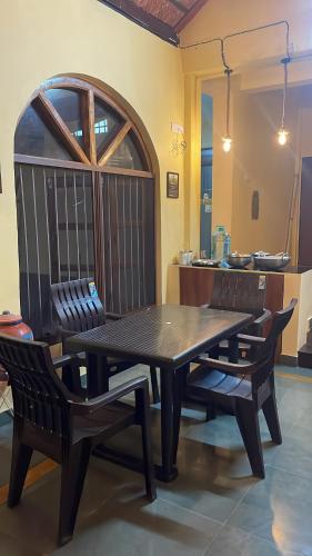 a wooden table and chairs in a room at Vana The Forest Farm in Saralgaon