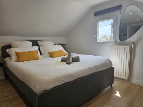 une chambre avec un grand lit avec des oreillers jaunes et blancs dans l'établissement Maison avec jardin, jacuzzi entre Paris et Disney, à Champigny-sur-Marne