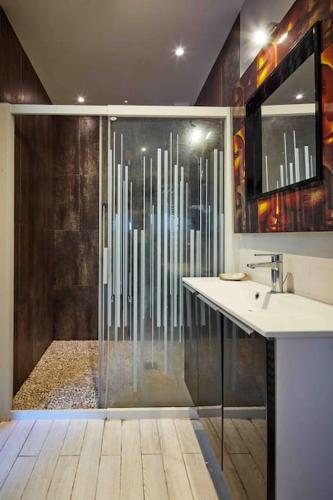 La salle de bains est pourvue d'une douche en verre, d'un lavabo et d'un lavabo. dans l'établissement Villa dans parc arboré, à Labenne