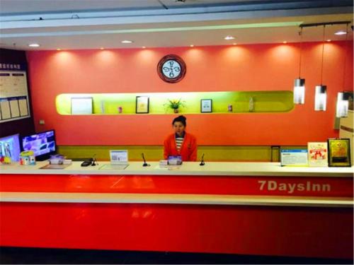 a woman standing at a counter in a store at 7Days Inn Harbin Chengde Plaza in Harbin