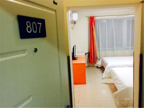 7Days Inn Harbin Chengde Plaza tesisinde bir odada yatak veya yataklar