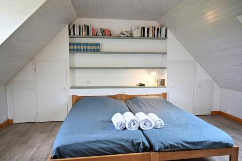 a bedroom with a bed with three pillows on it at Havre de paix à proximité de l'océan in Plonéour-Lanvern